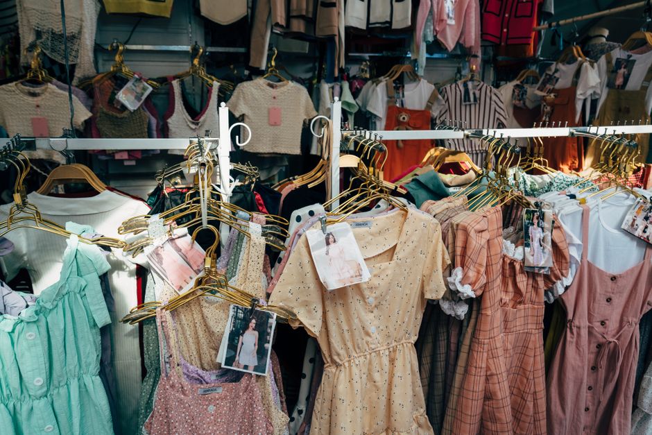 A colorful assortment of dresses hanging on a clothing rack in a trendy fashion boutique.